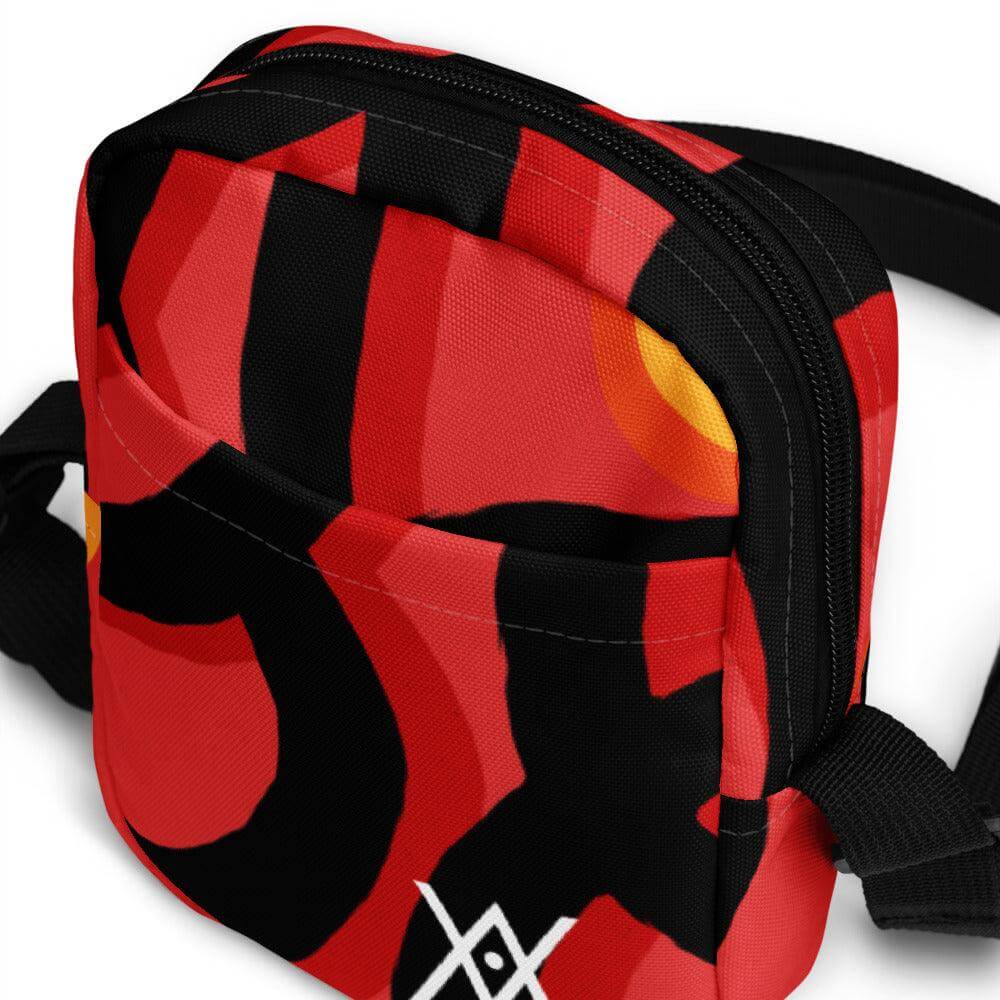 Hora Magica utility crossbody bag with red and black abstract design, adjustable straps, and zipped pockets for essentials.